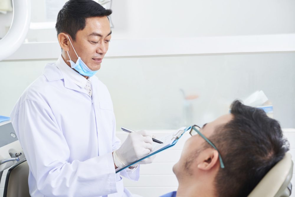 asian-male-dentist-at-work-D9DE6XX